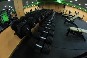 a gym with rows of dumbbells in a row at Margarita Hotel in Amman
