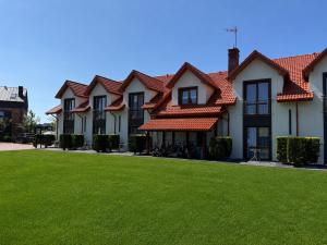 a row of houses with red roofs on a green lawn at Koja in Rowy