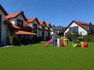 a yard with playground equipment in front of a house at Koja in Rowy +11 photos