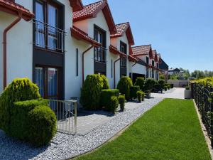 a row of houses with bushes and a walkway at Koja in Rowy