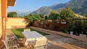 a patio with a table and chairs and a fence at Magazzini Sasso Guest House in Bussoleno