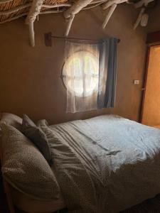 a bedroom with a bed and a window at Hobbit-Hole in Siwa in Siwa