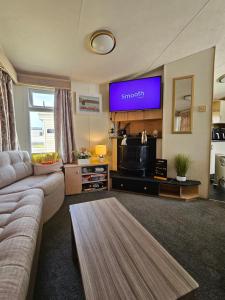 a living room with a couch and a flat screen tv at Nicks & Carmels by the sea in Heysham