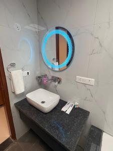 a bathroom with a sink and a mirror on a counter at Hotel Mikado Palace in Gurgaon