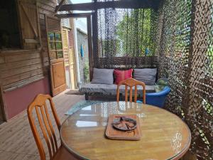 a patio with a table and chairs and a couch at A Kaz Robinson in Sainte-Luce +10 photos