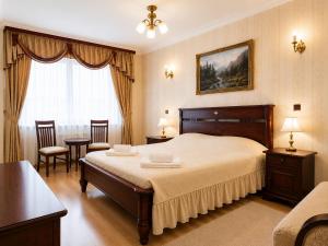 a bedroom with a bed and a table and chairs at Pensjonat Angela in Łeba
