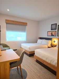 a hotel room with two beds and a desk at Hampton by Hilton Monterrey Tecnológico in Monterrey