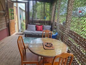 a patio with a table and chairs and a couch at A Kaz Robinson in Sainte-Luce