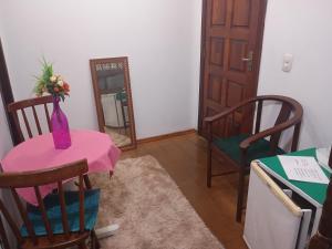 a room with a table and chairs and a mirror at Marins Pousada - Campos do Jordão in Campos do Jordão