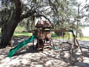 a playground with a slide and a tree at Lifetime of Vacations in Orlando