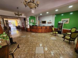 a lobby with green walls and chairs and a waiting room at Hotel Marsal in Antofagasta