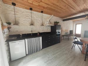 a kitchen with black cabinets and a wooden ceiling at Els Sifons in Castelltersol
