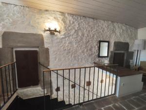 a room with a stone wall with a staircase at Els Sifons in Castelltersol