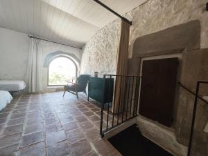 a bedroom with a fireplace and a bed and a window at Els Sifons in Castelltersol +14 photos