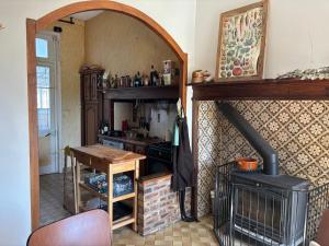 a kitchen with a stove and a table in a room at La briqueterie in Bourseville