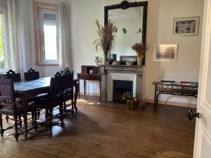 a dining room with a table and a mirror at La briqueterie in Bourseville +1 photo