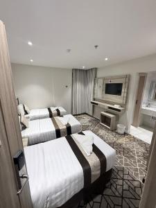 a hotel room with two beds and a television at Ritaj Al-Tala'i in Mecca