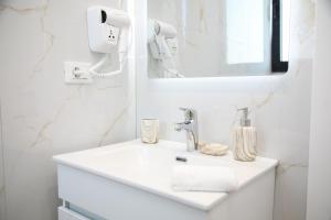 a white bathroom with a sink and a mirror at LiEl Holiday in Vlorë +95 photos