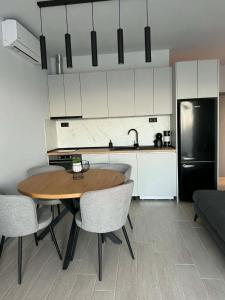 a kitchen with a table and chairs and a black refrigerator at Blue Breeze in Sinemorets
