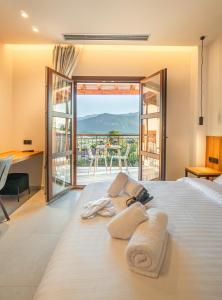 a bedroom with a bed with a view of a balcony at Terra Petra Meteora in Kalabaka