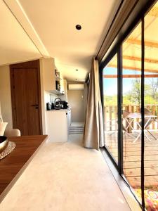 a kitchen and living room with a sliding glass door at O'BARA Lodge - Tiny House - Jardin et climatisation in Druillat