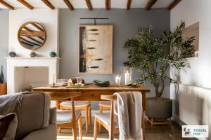 a dining room with a wooden table and chairs at Charlotte's Cottage, a Charming Cotswolds Getaway in Adlestrop