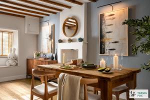 a dining room with a wooden table and chairs at Charlotte's Cottage, a Charming Cotswolds Getaway in Adlestrop