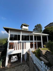 a white house with a car parked in front of it at Oli Villa in Belihuloya