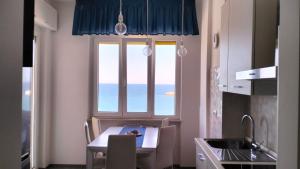 a kitchen with a table and a large window at IL CIELO SUL MARE in Bisceglie