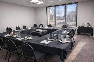 ein Konferenzraum mit Tischen, Stühlen und einem Laptop in der Unterkunft Hotel de la Rive in Sorel + 29 Fotos