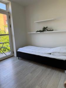 a white room with a bed and a window at Lille Vedelsborg 1 in Vejle