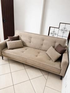 a couch sitting in a living room at Studio aconchegante com ar-condicionado e Smart TV in Bauru