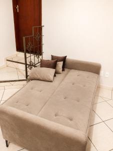 a large couch sitting in a living room at Studio aconchegante com ar-condicionado e Smart TV in Bauru