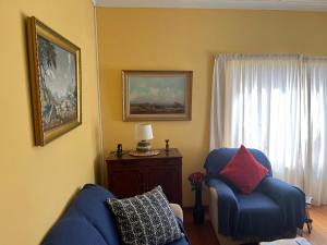ein Wohnzimmer mit zwei blauen Sesseln und einem Fenster in der Unterkunft DKC Accommodation in Sutherland