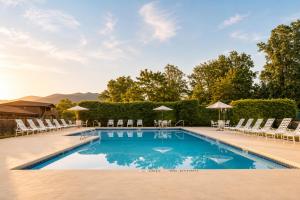 a swimming pool with chairs and umbrellas at The Dillard House in Dillard