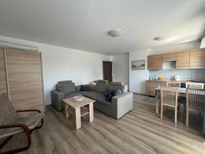 a living room with a couch and a table and a kitchen at Pokoje i apartamenty Pod Dębem in Rowy