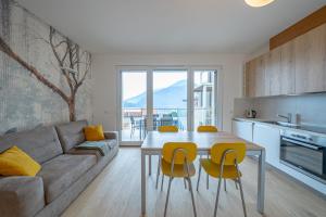 eine Küche und ein Wohnzimmer mit einem Tisch und gelben Stühlen in der Unterkunft Appartamento Due Stelle Musso in Musso