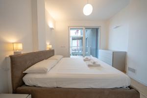 ein Schlafzimmer mit einem großen Bett mit weißer Bettwäsche in der Unterkunft Appartamento Due Stelle Musso in Musso + 29 Fotos