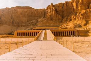 a stairway leading up to a building with a mountain at Vipxplor Travel in Luxor