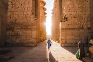a man walking through an alley in the ruins of a building at Vipxplor Travel in Luxor +5 photos