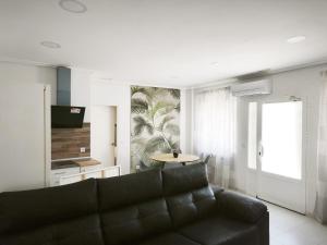 a living room with a couch and a table at Apartamentos Joli in Olivares de Duero