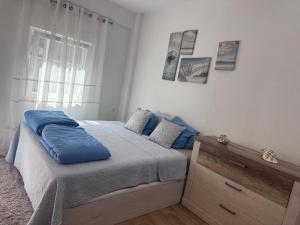 a bedroom with a bed with blue pillows on it at Domek v srdci Fara in Faro