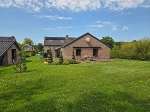 a house with a green lawn in front of it at Le 42 Durbuy in Durbuy