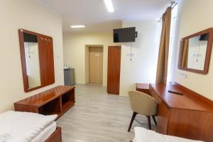 a room with a desk and a bed and a mirror at Kolegium Nowe PANS - hostel in Przemyśl