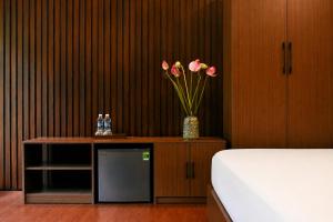 a bedroom with a vase of flowers on a cabinet at Tam Coc Aurora Valley in Vũ Lâm