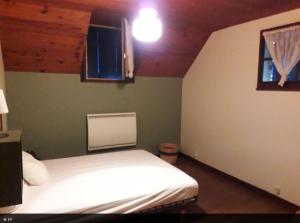 a bedroom with a white bed and a window at La maison de la Mouline in Arette