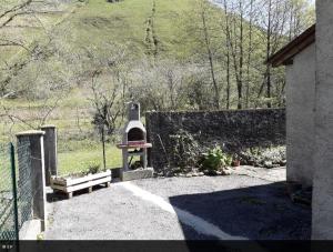 a backyard with a brick oven next to a fence at La maison de la Mouline in Arette +1 photo