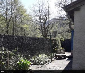 a garden with a bench next to a wall at La maison de la Mouline in Arette