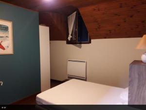 a bedroom with a white bed and a fan at La maison de la Mouline in Arette
