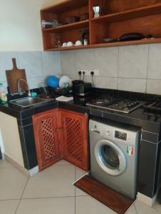 a kitchen with a washing machine and a sink at Beach front Spacious Studio in Malindi
